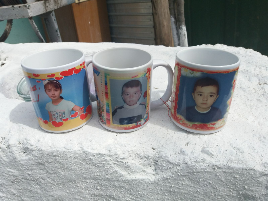 Chipul lui Cristi (centru) a rămas doar pe o cană. În stânga și în dreapta sunt căni cu fețele fraților săi