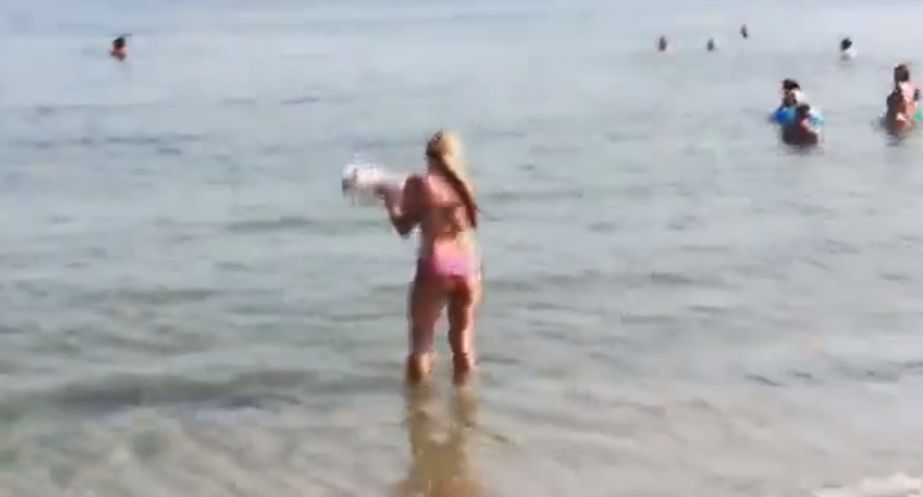 Tânără, surprinsă în timp ce-și curăța câinele de excremente în apa mării, după ce animalul și-a făcut nevoile pe plajă!