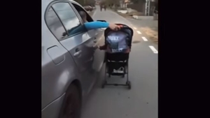 Un tânăr, filmat în timp ce-şi plimbă bebeluşul în cărucior, din maşina pe care o conduce! Ce-a urmat apoi întrece orice imaginație