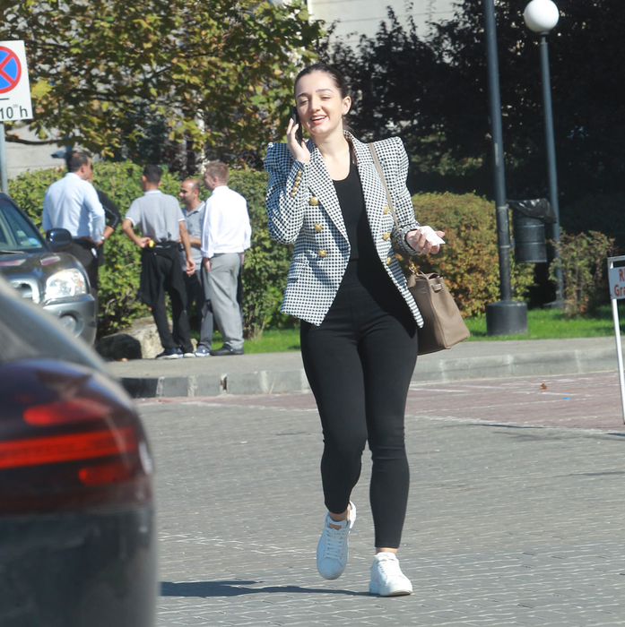 Theodora zâmbește în timp ce vorbește la telefon