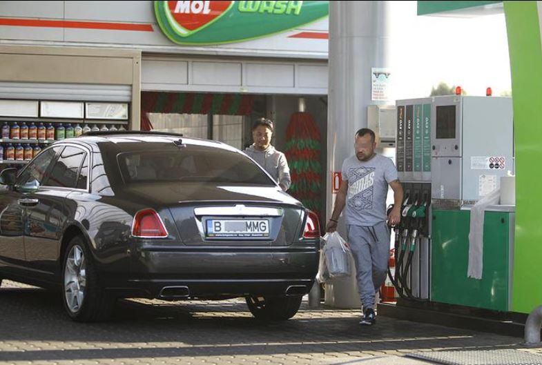 Tanaka, alături de șoferul lui, după o aprovizionare într-o benzinărie