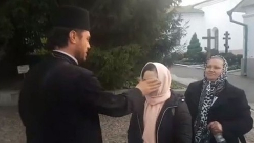 Cascadorii râsului în curtea bisericii. Credincioșii, plesniți cu agheasmă peste ochi