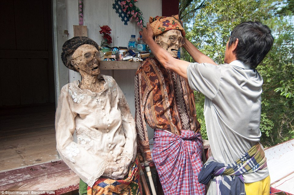 Ritual bizar pe o insula din Indonezia! O dată la trei ani, familiile își dezgroapă morții și apoi stau cu ei la o țigară