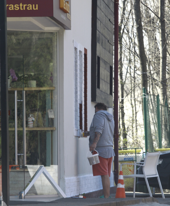 Fiul lui Adrian Petrache zugrăveşte faţada restauranului pe care tatăl lui i l-a lăsat în grijă.