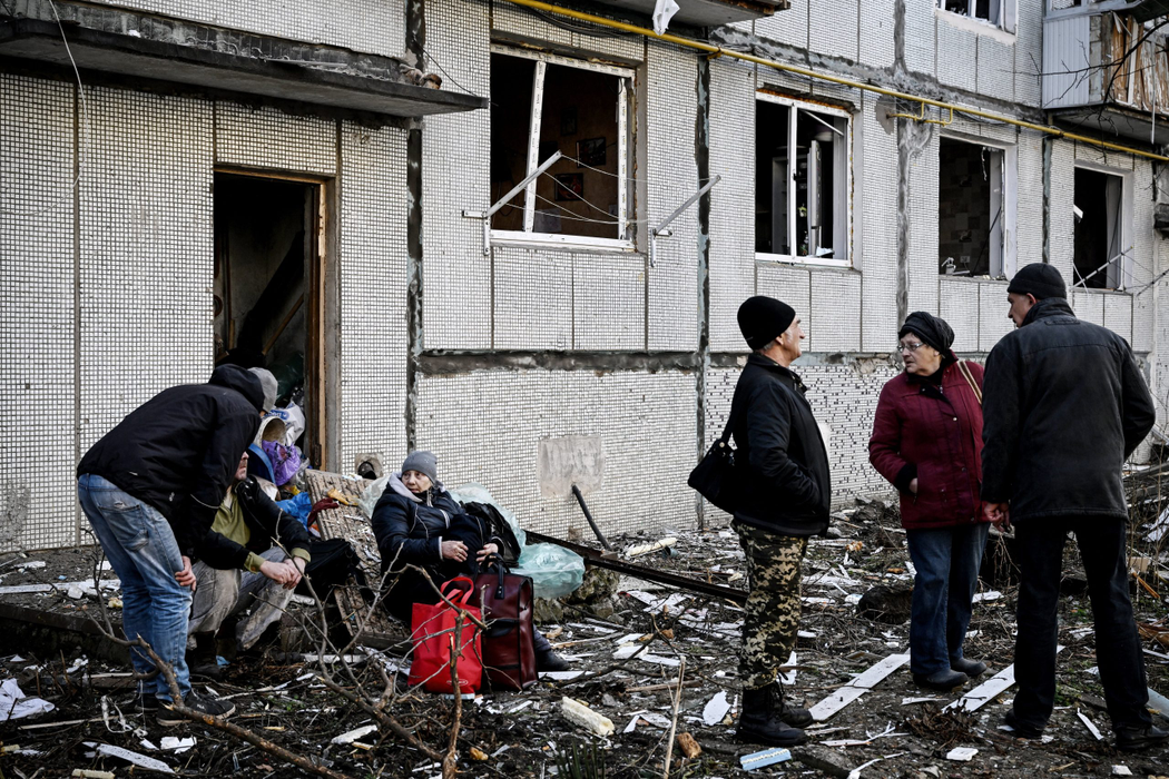 Oamenii părăsesc clădirea distrusă, după bombardamentele asupra orașului Chuguiv, din estul Ucrainei, pe 24 februarie 2022. (Sursa foto: profimedia.ro)
