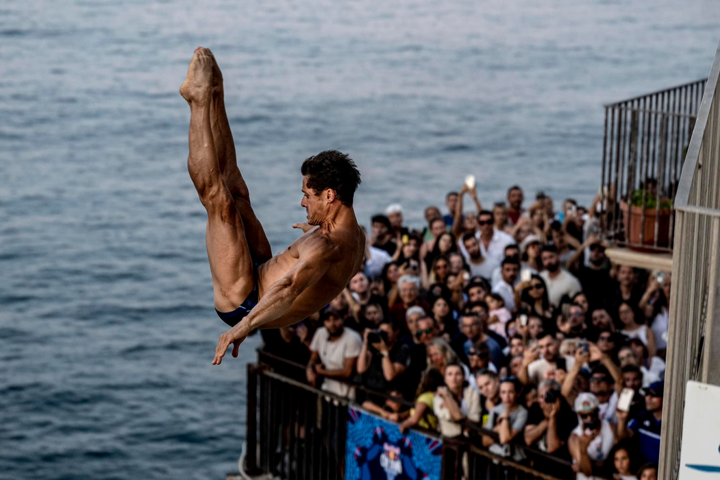Constantin Popovici, surprins când executa o săritură de la o înălțime de aproximativ 26 de metri, la competiția Red Bull Cliff Diving World Series, din Italia foto: Dean Treml