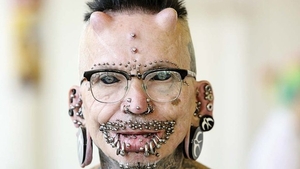 Are 453 de piercinguri, e tatuat tot, are limba despicată și coarne de titan în frunte! Și totul nu se oprește aici