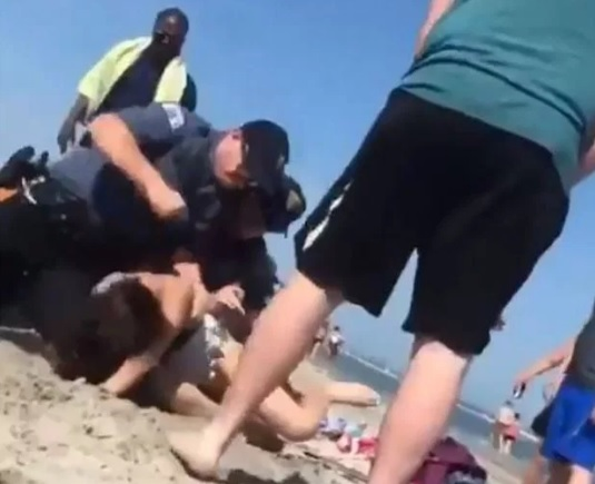 O femeie a fost ruptă cu bătaia de polițiști, pe plajă. Imagini halucinante