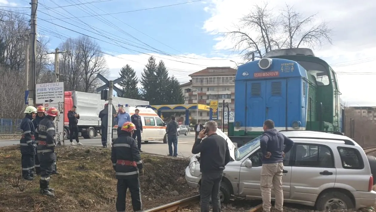 VIDEO. Accident feroviar la Pucioasa. O locomotivă a lovit o mașină, doi răniți au fost transportați la spital
