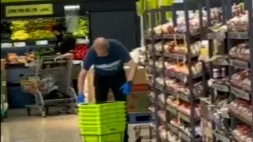 Caz revoltător! Angajatul unui supermarket a fost filmat când ștergea coșurile cu propria salivă