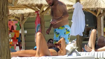 VIDEO EXCLUSIV. Soţia a dispărut din peisaj, iar el… Milionarul BLUE AIR, 
suspect de jucăuş cu o sexoasă la plajă!