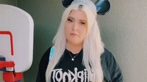 Motivul bizar pentru care femeia din imagine a fost obligată să își schimbe îmbrăcămintea în parcul Disney. Ce scrie pe tricoul ei