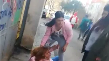 IMAGINI ŞOCANTE. Elevă de liceu din Alexandria, bătută cu pumnii şi cu picioarele, pe stradă, de una dintre colegele ei