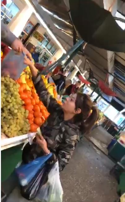 Ana Maria își alege mandarinele, pe care le pune în plasă