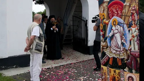 Imagini unice. Episcopul din Slatina, primit cu... covor de petale de trandafiri la Slătioara. Sătenii au adunat florile din curți și le-au împrăștiat pe stradă