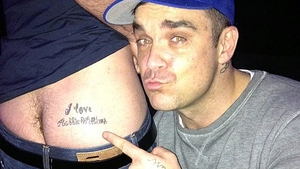 Un fan il trateaza cu fundul pe idolul lui, Robbie Williams. Mesajul de pe fesier i-a intrat la suflet artistului