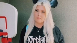 Motivul bizar pentru care femeia din imagine a fost obligată să își schimbe îmbrăcămintea în parcul Disney. Ce scrie pe tricoul ei