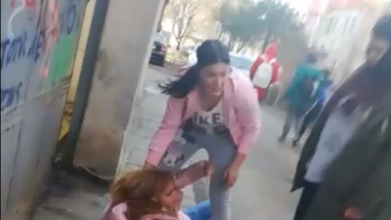 IMAGINI ŞOCANTE. Elevă de liceu din Alexandria, bătută cu pumnii şi cu picioarele, pe stradă, de una dintre colegele ei