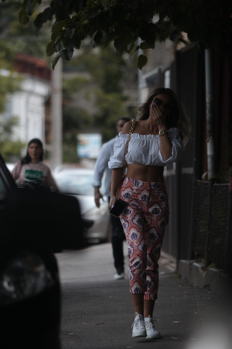 Bianca Drăgușanu a ieșit din curtea salonului  și se îndreaptă către mașină, urmărită de Alex Bodi
