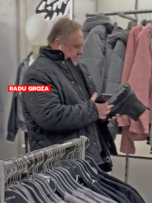 Radu Groza se uită la o pereche de ghete