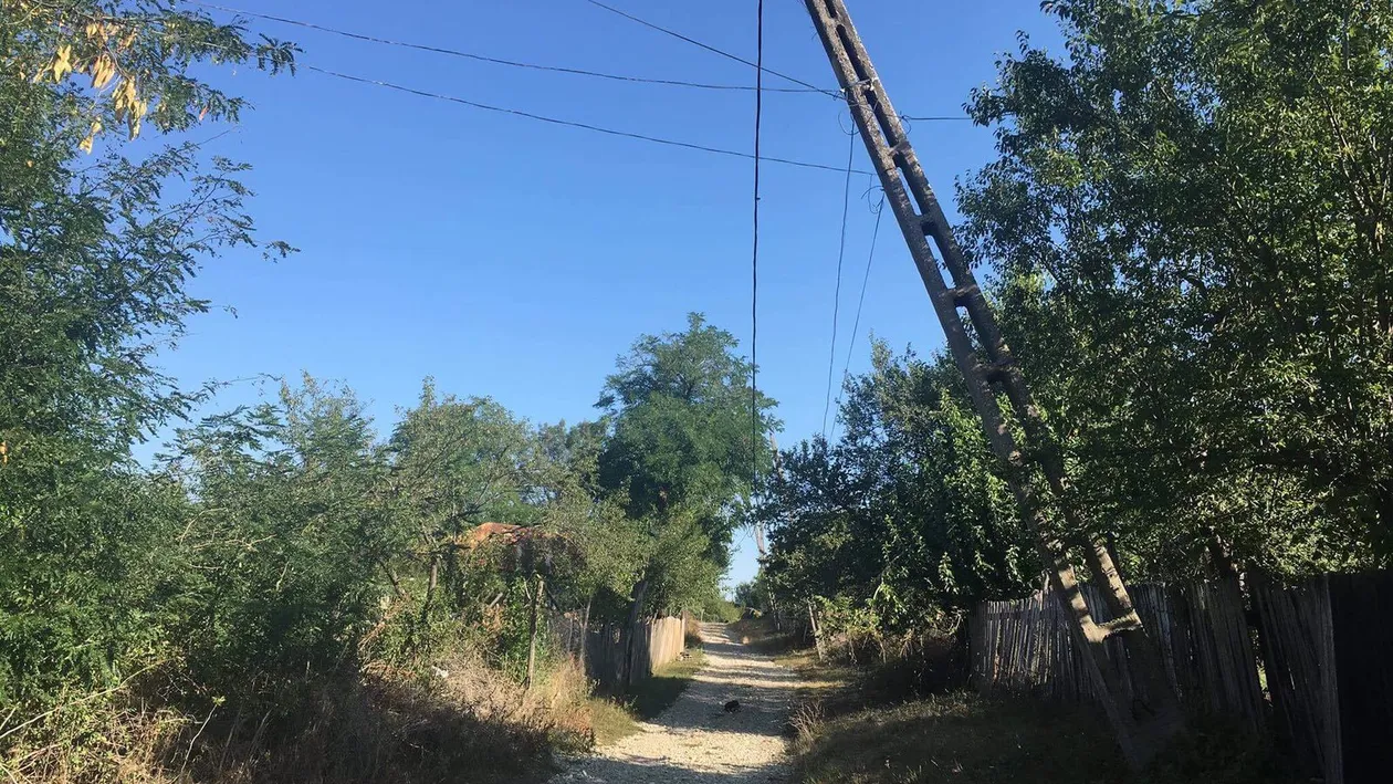 Locuitorii unui sat din Dolj trăiesc de şapte ani cu frica să nu le cadă stâlpii de electricitate pe case