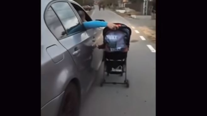 Un tânăr, filmat în timp ce-şi plimbă bebeluşul în cărucior, din maşina pe care o conduce! Ce-a urmat apoi întrece orice imaginație