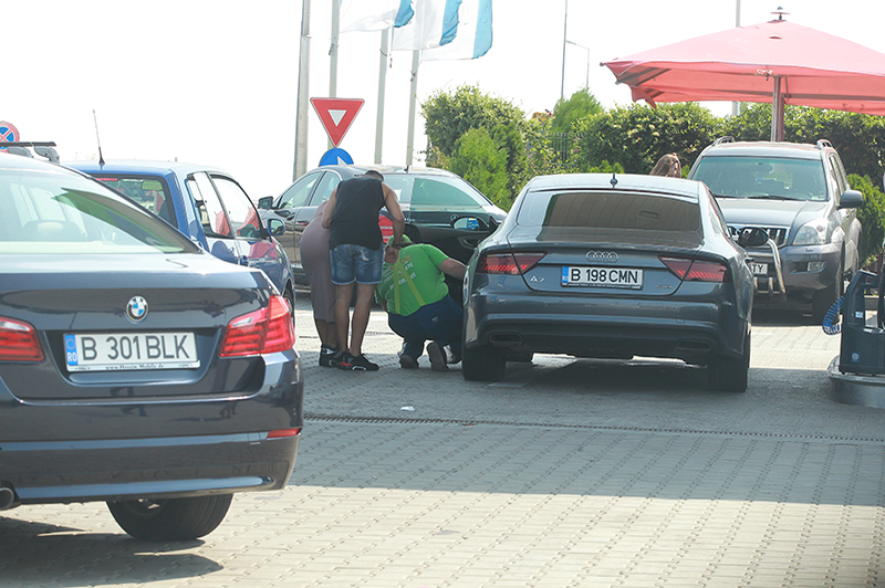 Un angajat al benzinăriei verifică pneurile