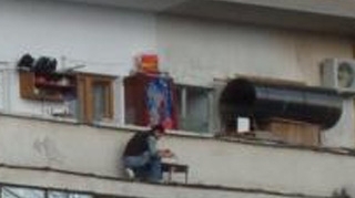 Singurul loc unde nu te asteptai sa vezi vreun cocalar facand gratar! Uite-l pe asta cum isi risca viata stand la etajul 7, pe marginea balconului, la cativa centimetri sa cada in gol!