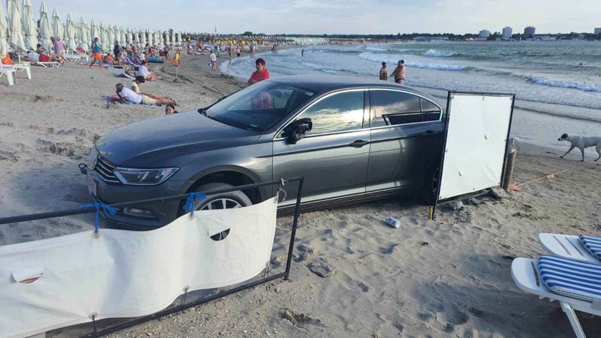Incredibil! Imagini cu mașina unui turist parcată pe plajă, printre șezlonguri, în Saturn. Salvamarii au sunat la poliție